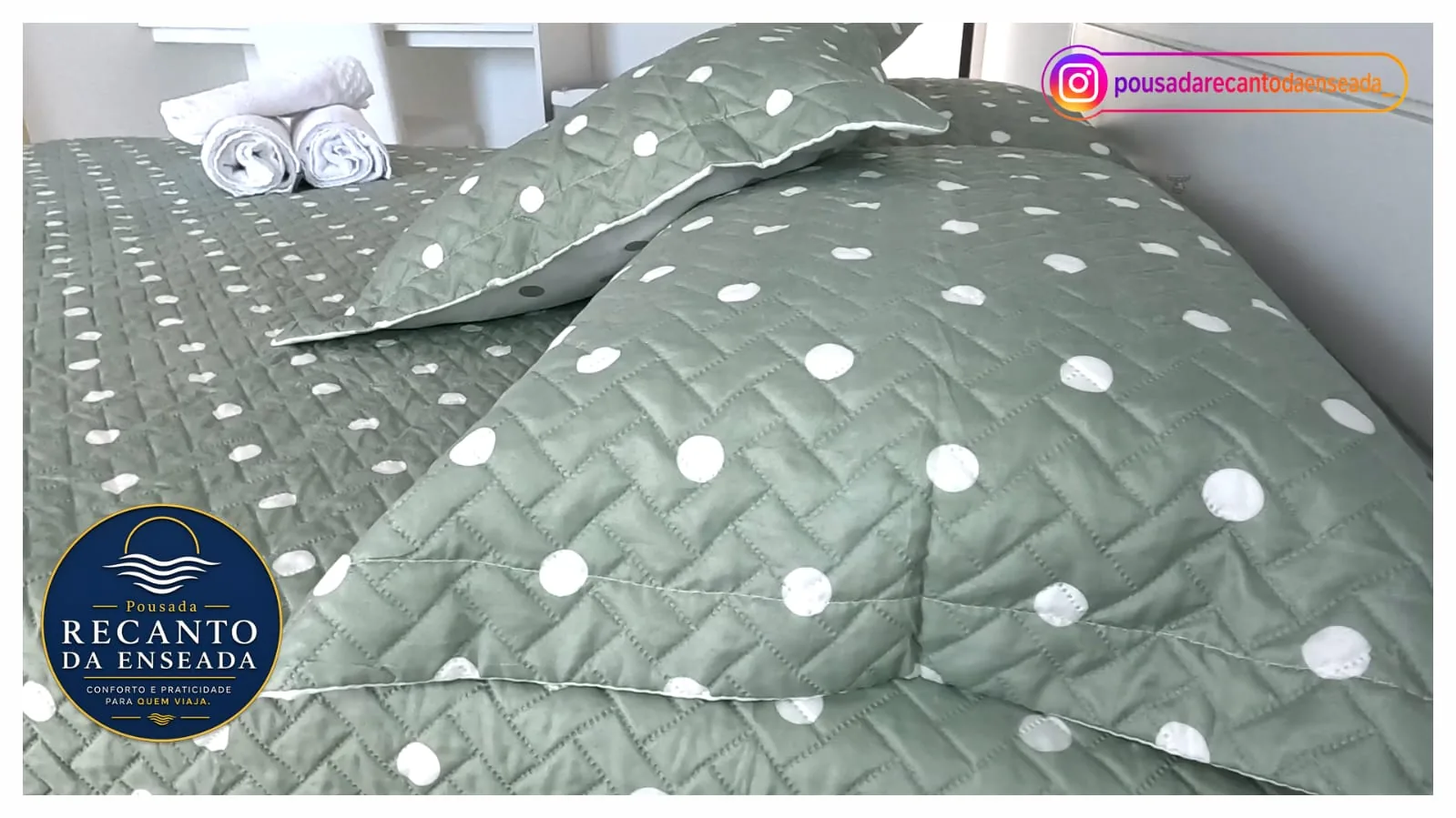 Cama arrumada com toalhas dobradas em uma suíte